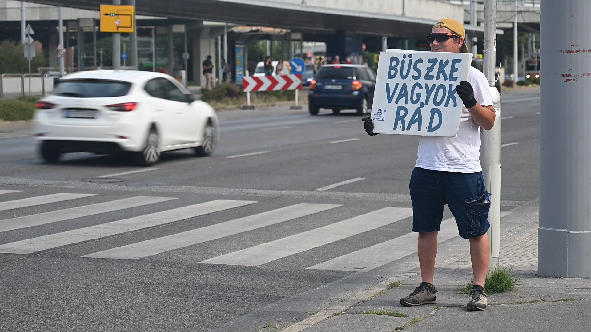 férfi táblát tart az autóknak